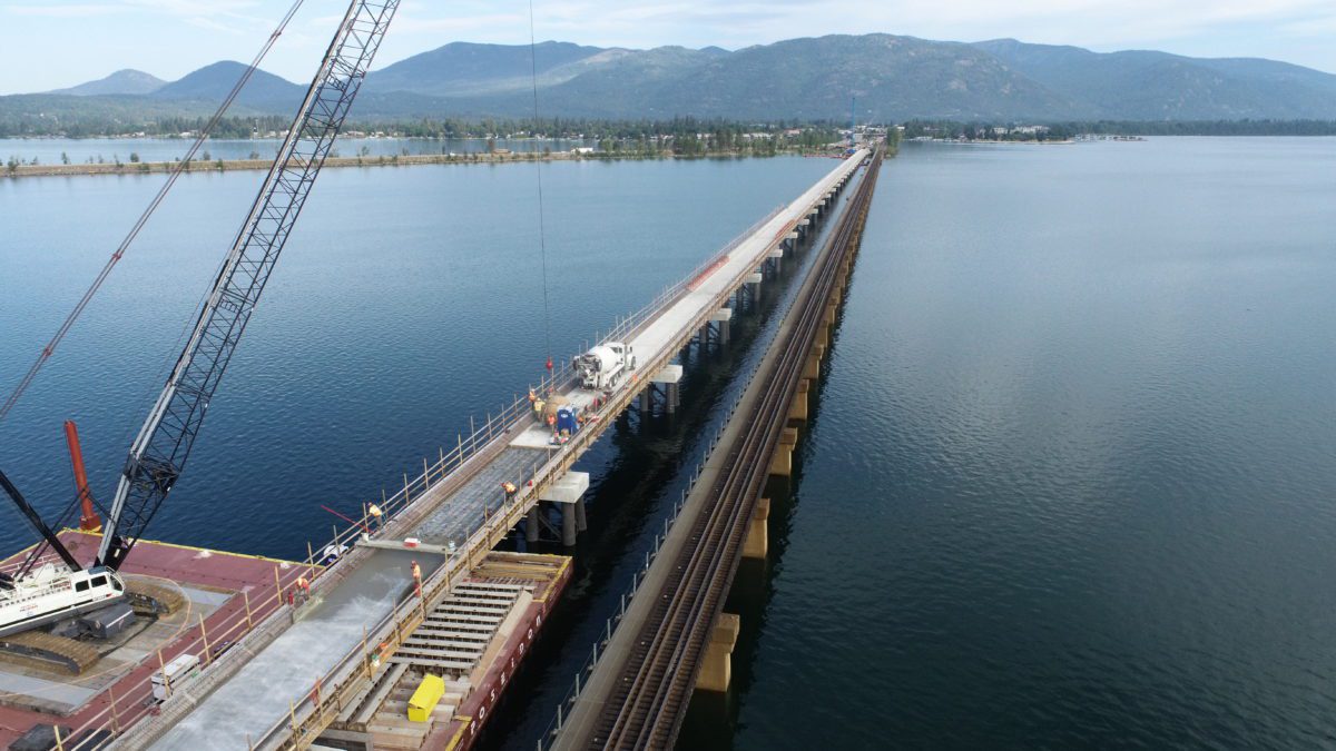 A birds-eye view of the bridge construction with a crane in the foreground.